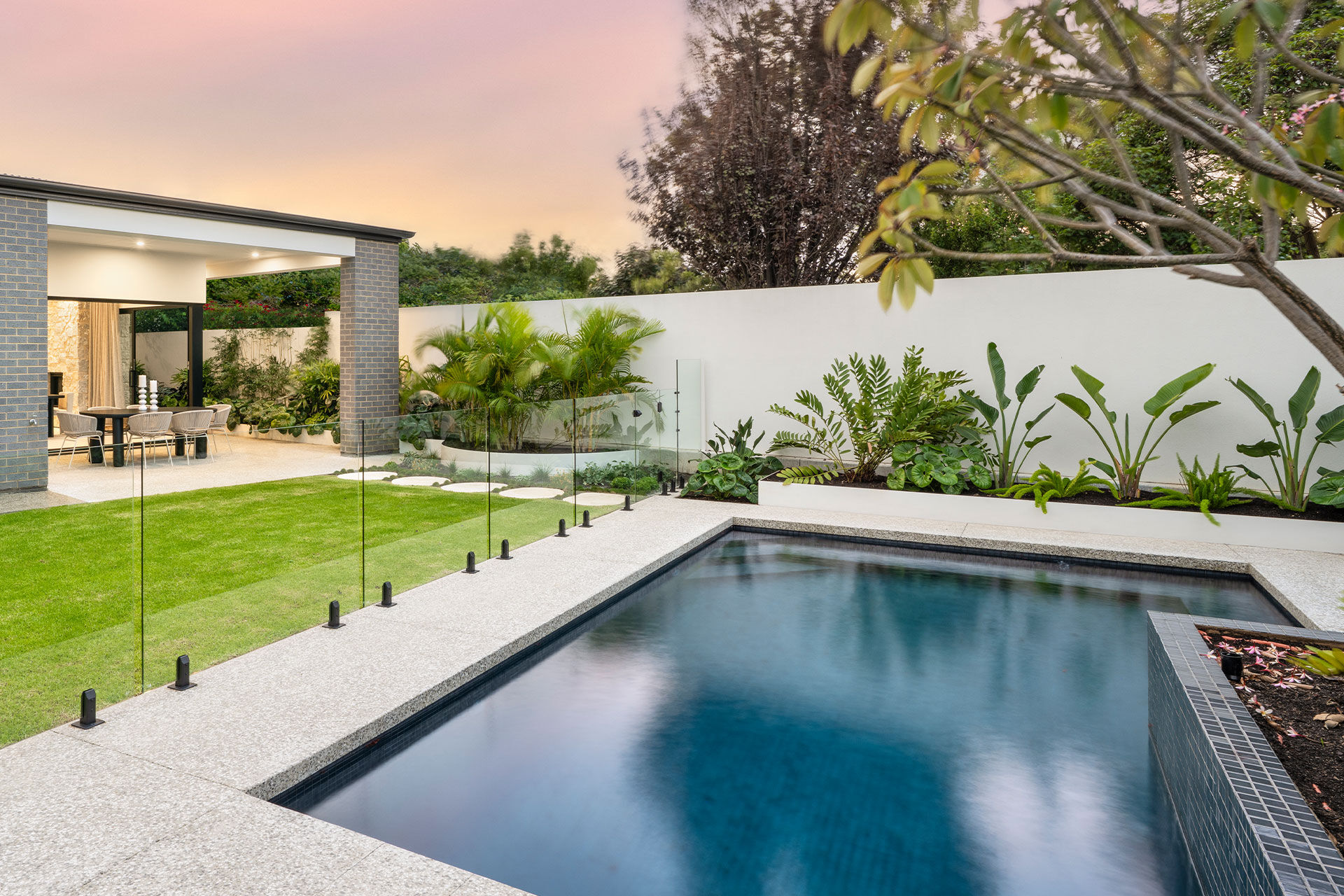 Backyard pool area with lush landscaping