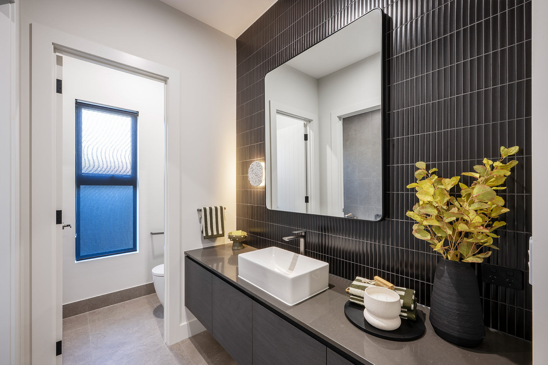 Grand Prize powder room with dark grey tiles