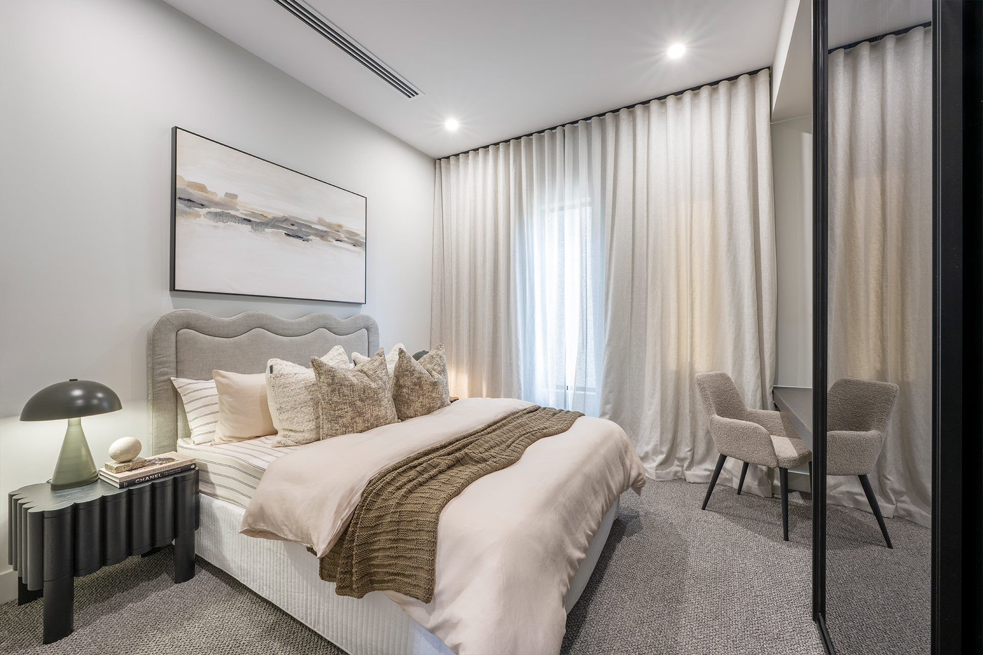 Grand Prize bedroom with beige and grey bedding with soft linen curtains covering the window