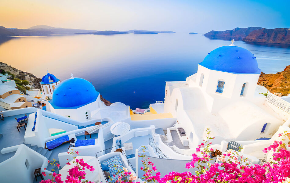 Landscape overhead view of iconic blue and white greek houses along coastline with blue sea in the background