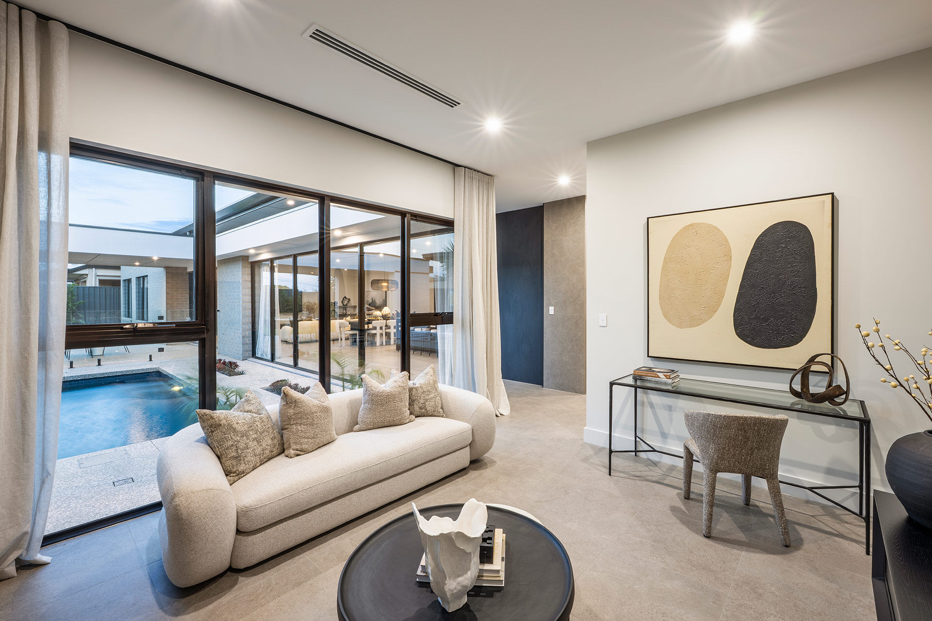 Grand Prize lounge room with cream sofa with windows to the pool area