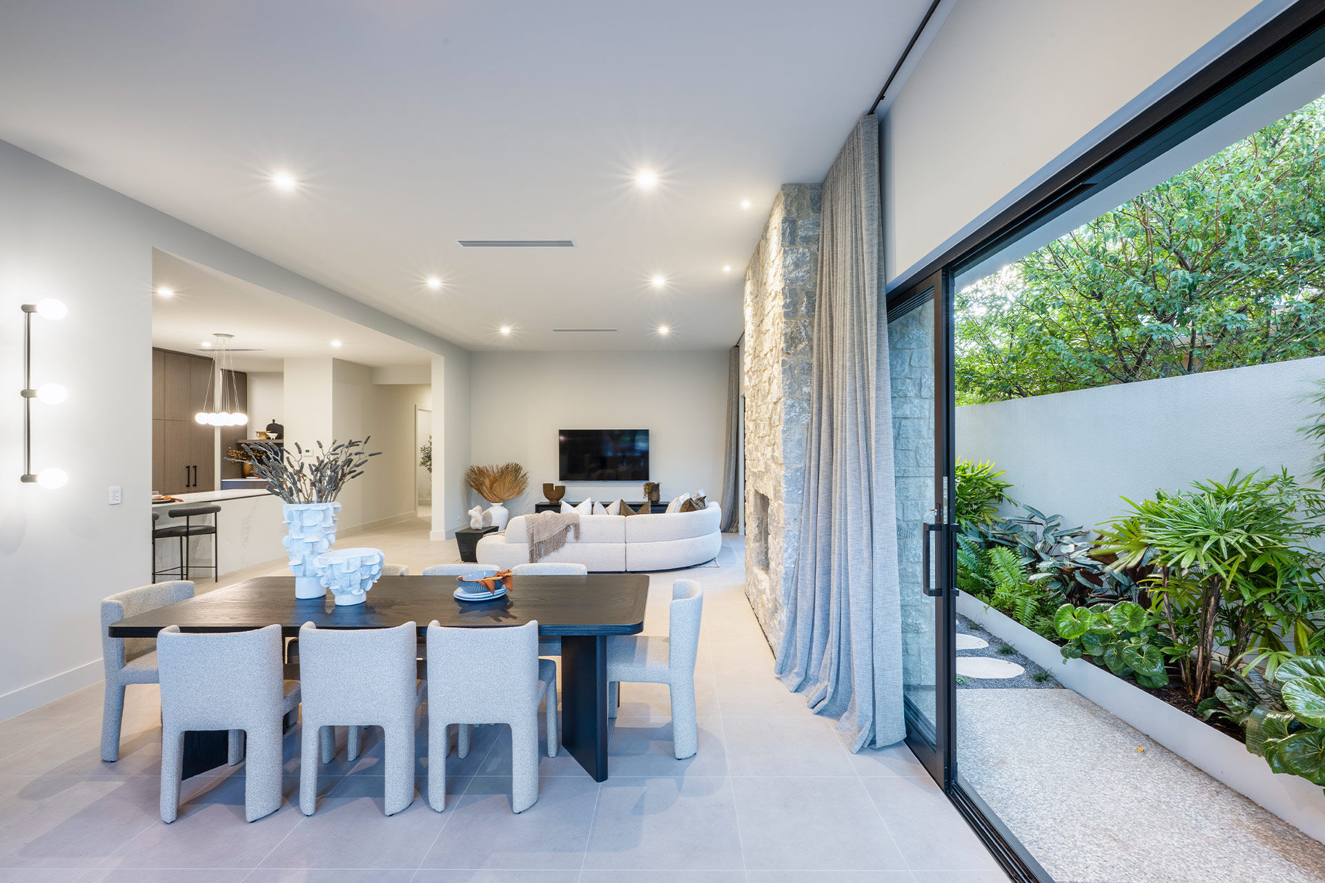 Dining room table with rounded fabric chairs and sculptural vases