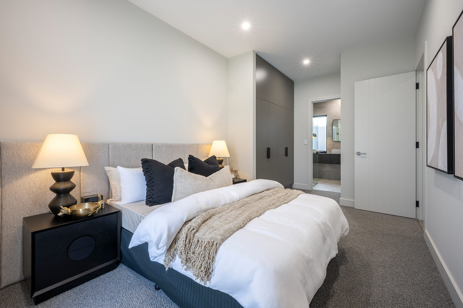 Grand Prize bedroom with beige and grey bedding leading to small ensuite bathroom