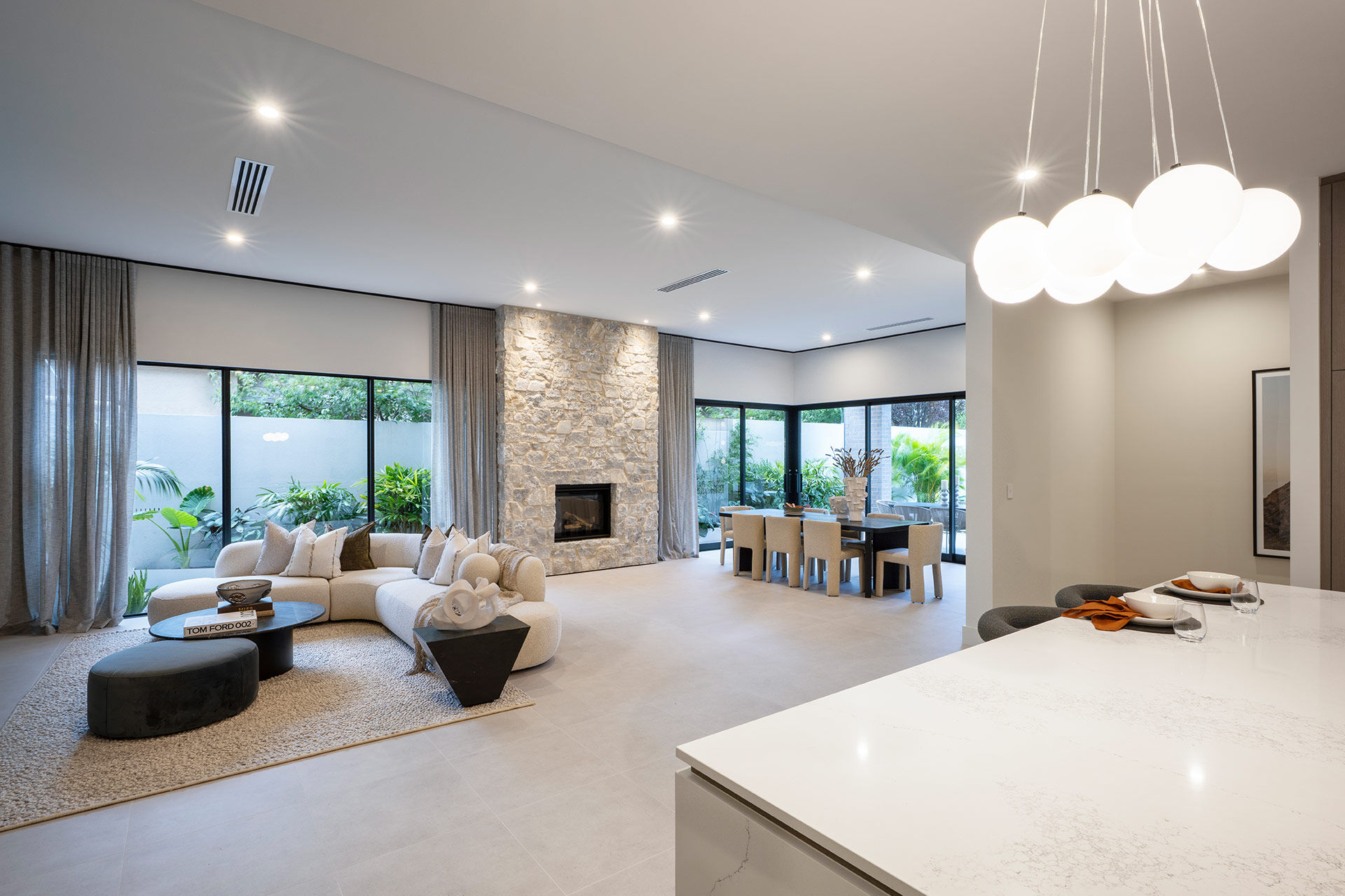 Angled view from kitchen to the living and dining with stone fireplace