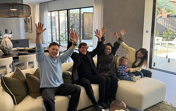 Winner Roasana celebrating with family arms in the air